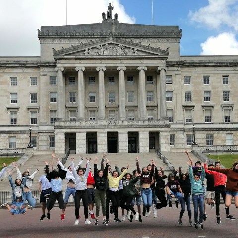 group jumping in front of a building in Belfast
