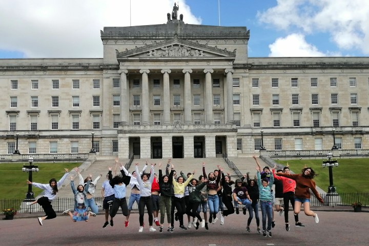 group jumping in front of a building in Belfast